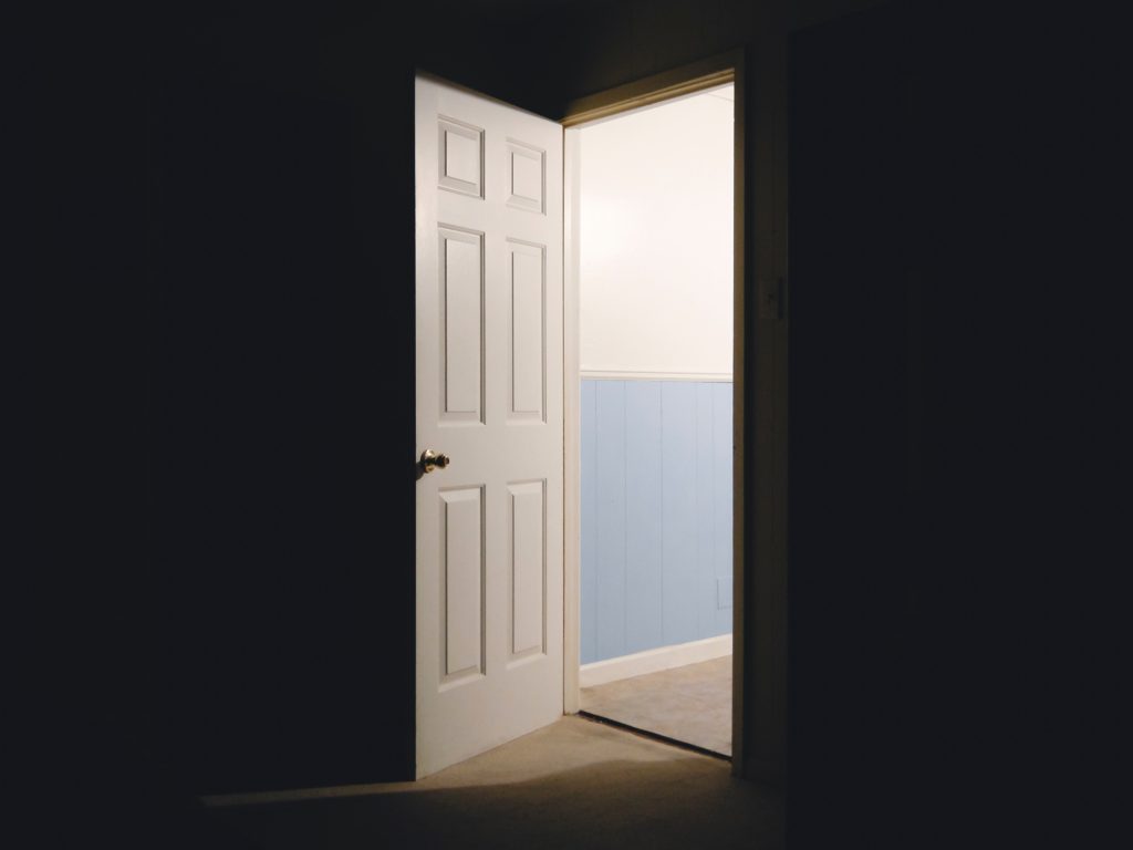 Photo of an open door with black background